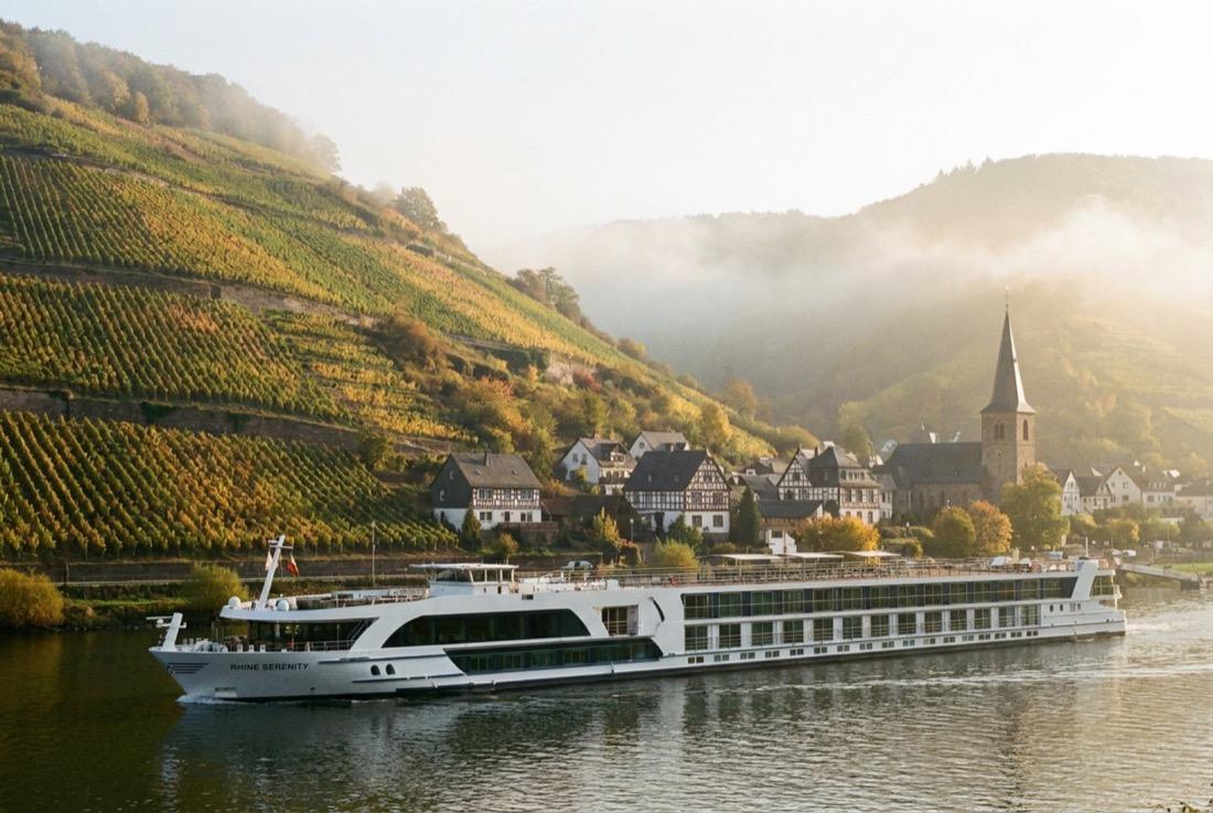 Flusskreuzfahrtschiff auf dem Rhein vor Weinbergen