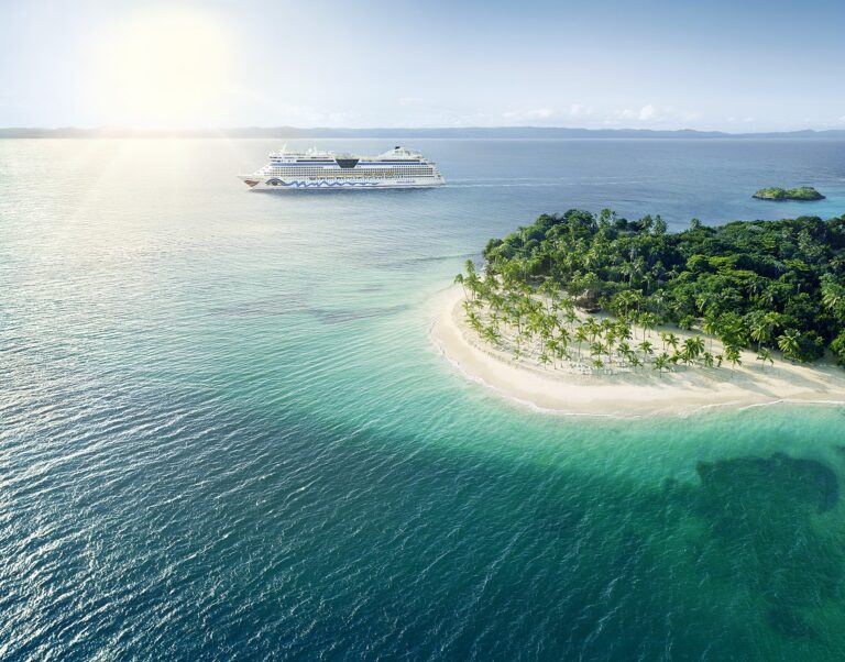 Die AIDAdiva vor einer Insel in der Karibik